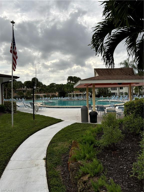 4180 Looking Glass Lane, Unit 4104 Naples, FL 34112 - Photo 20 of 30 a view of a swimming pool with an outdoor seating and a yard