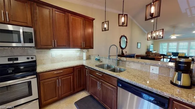 a kitchen with granite countertop a sink stainless steel appliances and cabinets