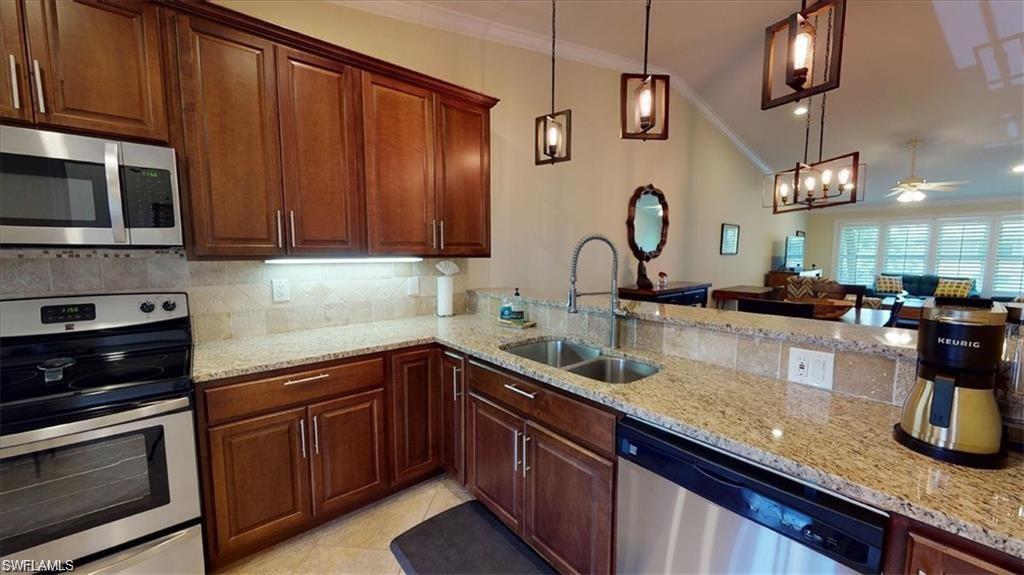 4180 Looking Glass Lane, Unit 4104 Naples, FL 34112 - Photo 4 of 30 a kitchen with granite countertop a sink stainless steel appliances and cabinets