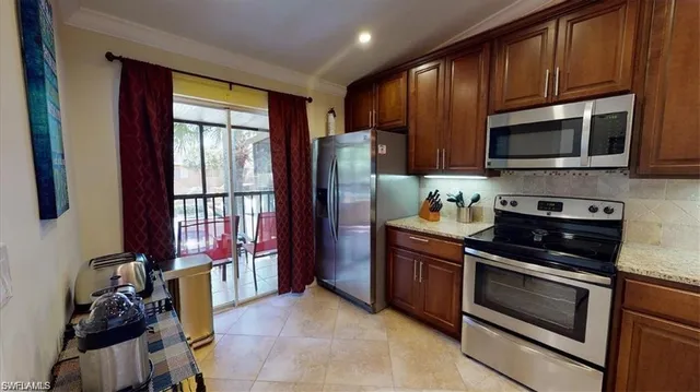 a kitchen with stainless steel appliances granite countertop a stove microwave and refrigerator