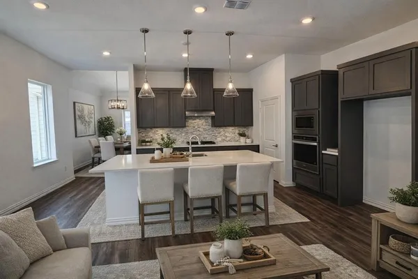 a living room with stainless steel appliances kitchen island granite countertop furniture and wooden floor