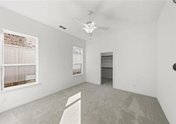 an empty room with windows and cabinet