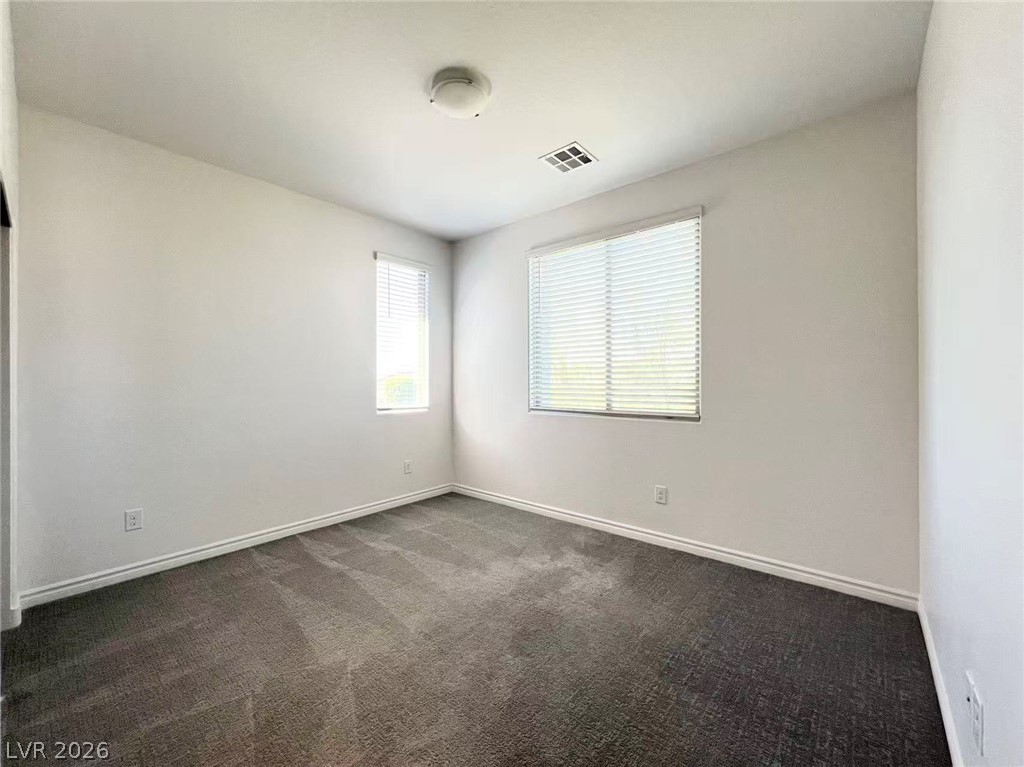 925 Bayberry Ridge Street Henderson, NV 89052 - Photo 19 of 27 An inviting room provides ample space and features soft carpeting, perfect for a cozy retreat.