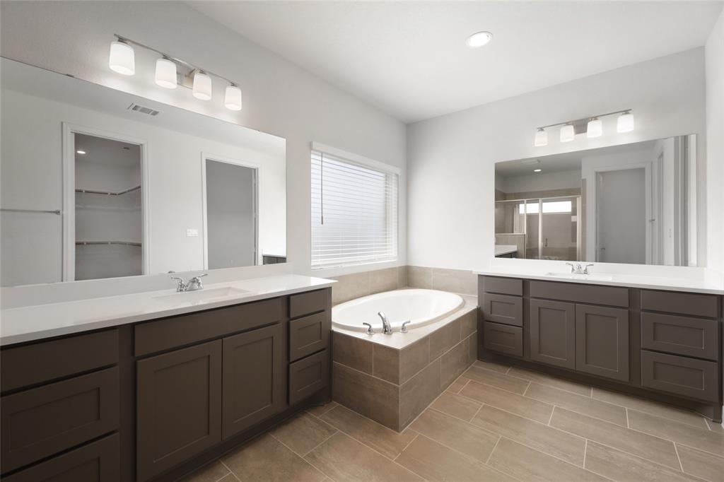 123 Plumbago Loop Bastrop, TX 78602 - Photo 13 of 40 a bathroom with a granite countertop double vanity sink and mirror with bathtub