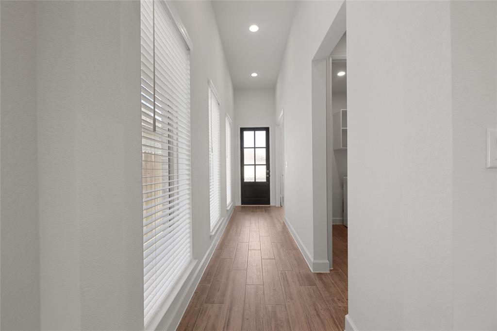 123 Plumbago Loop Bastrop, TX 78602 - Photo 4 of 40 a view of a hallway with wooden floor and a bathroom