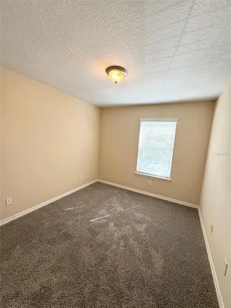 an empty room with windows and mirror