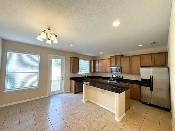 a kitchen with stainless steel appliances granite countertop a stove a sink and a refrigerator