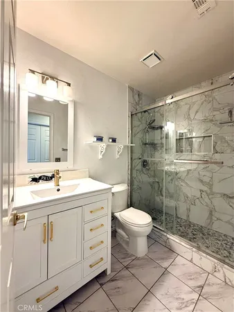 a bathroom with a double vanity sink toilet and shower