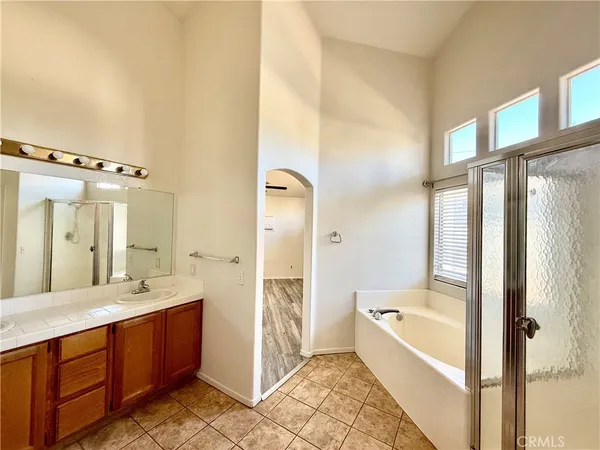 a large bathroom with a tub shower and sink
