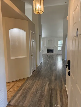 a view of a livingroom with wooden floor and a kitchen space