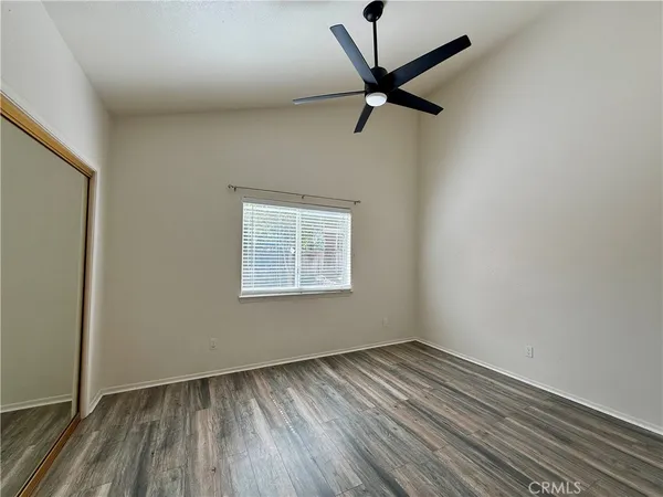 an empty room with a window and a ceiling fan