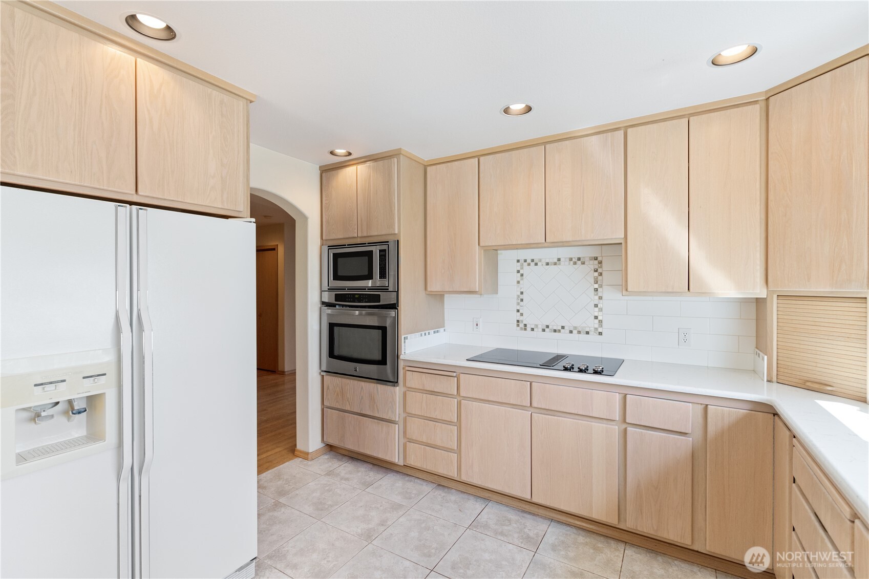 292 Foursome Drive Sequim, WA 98382 - Photo 14 of 32 a kitchen with kitchen island white cabinets and refrigerator