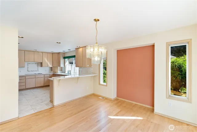 a kitchen with stainless steel appliances granite countertop a refrigerator a sink dishwasher a stove and white cabinets with wooden floor