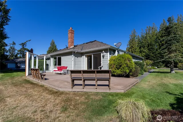 a view of a house with backyard and sitting area