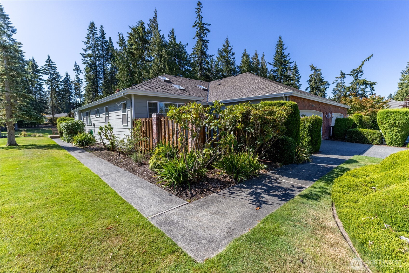 292 Foursome Drive Sequim, WA 98382 - Photo 32 of 32 a view of a garden with a table and chairs under an umbrella
