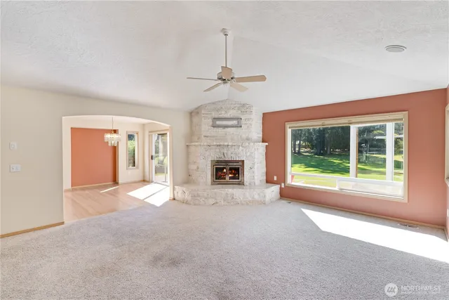a view of an empty room with a fireplace and a window