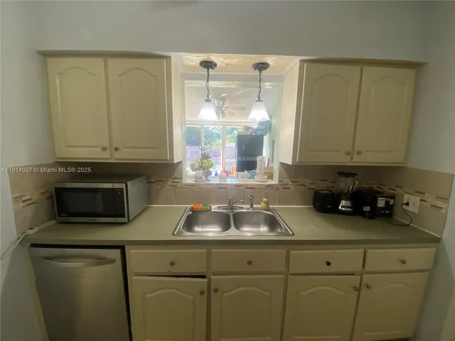 a kitchen with a sink a window and cabinets