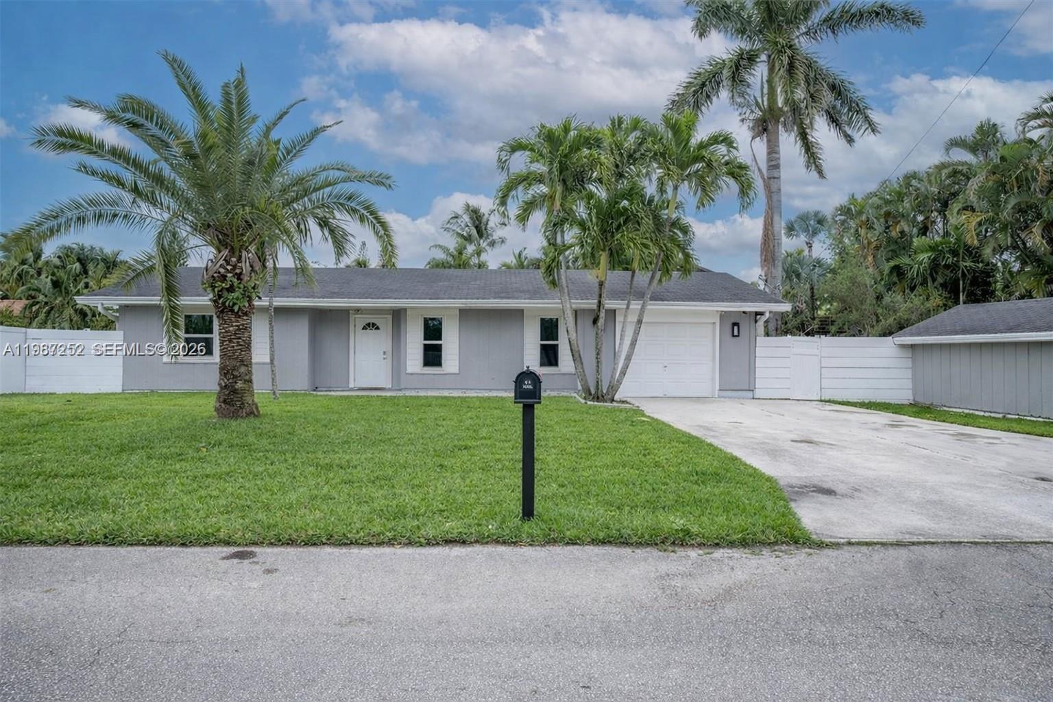 4541 Southwest 28th Terrace Dania Beach, FL 33312 - Photo 1 of 9 a front view of a house with a garden and palm tree