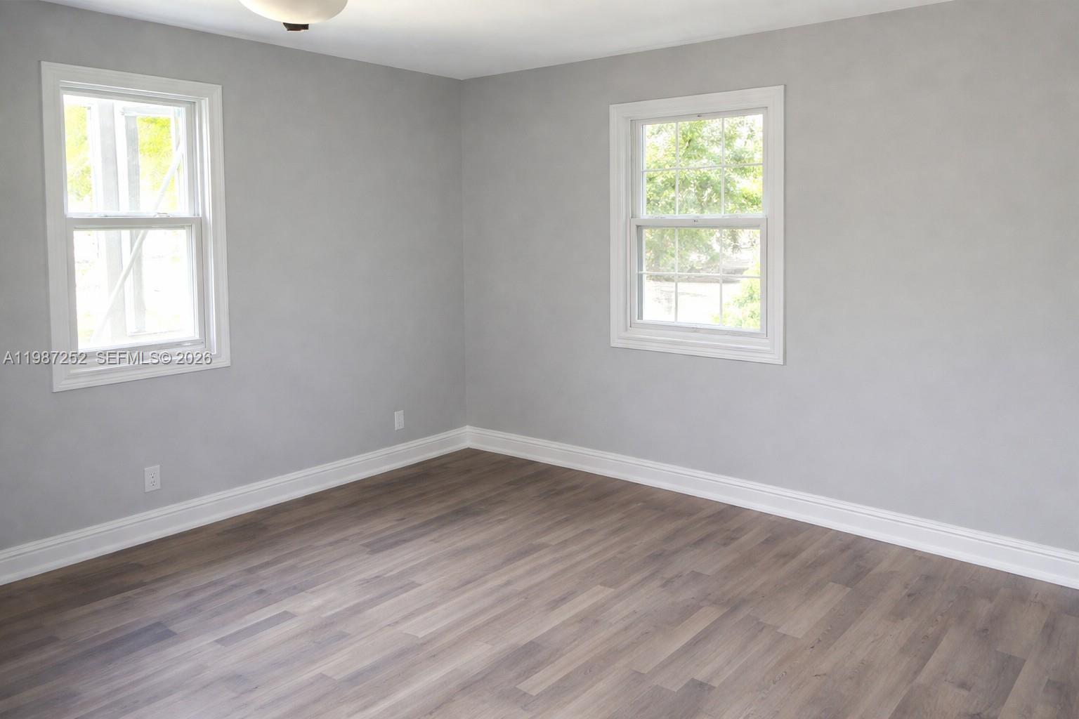 4541 Southwest 28th Terrace Dania Beach, FL 33312 - Photo 5 of 9 an empty room with wooden floor and windows