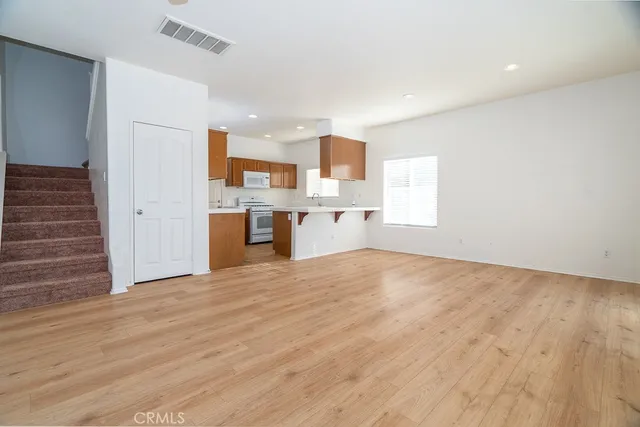 a view of a kitchen with wooden floor and a sink cabinets