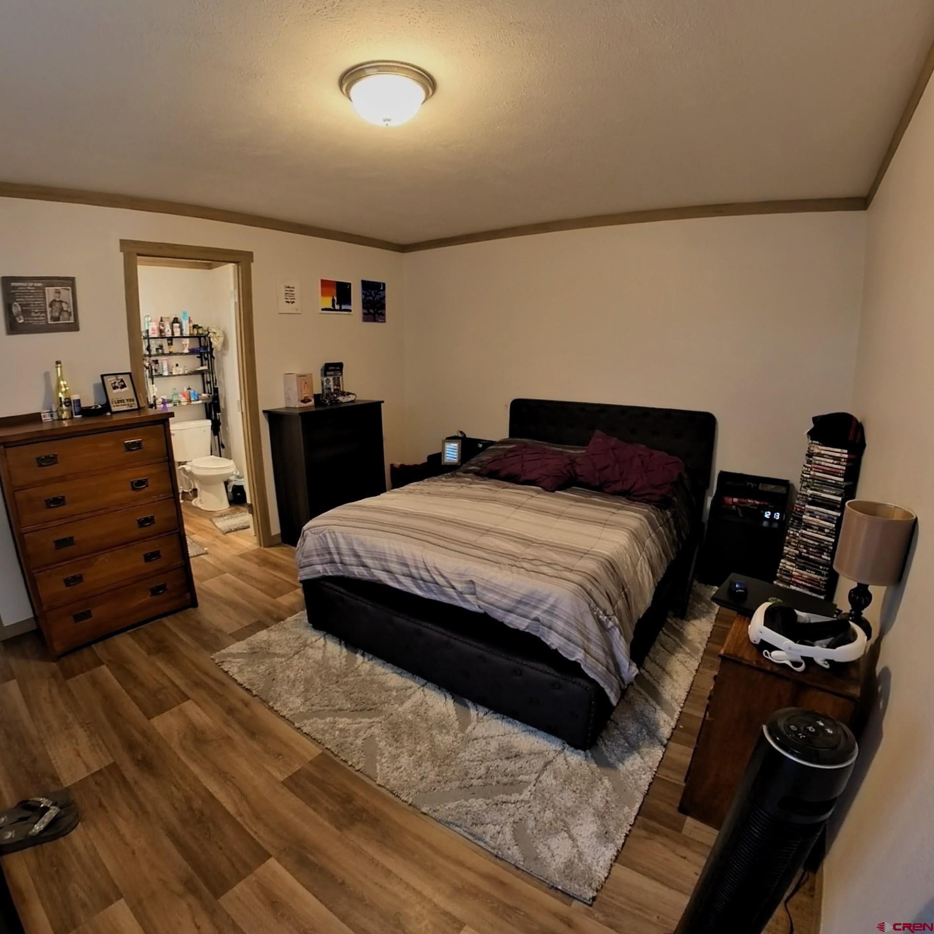 62650 Lasalle Road, Unit 822 Montrose, CO 81403 - Photo 11 of 17 a bedroom with a bed and dresser with chair