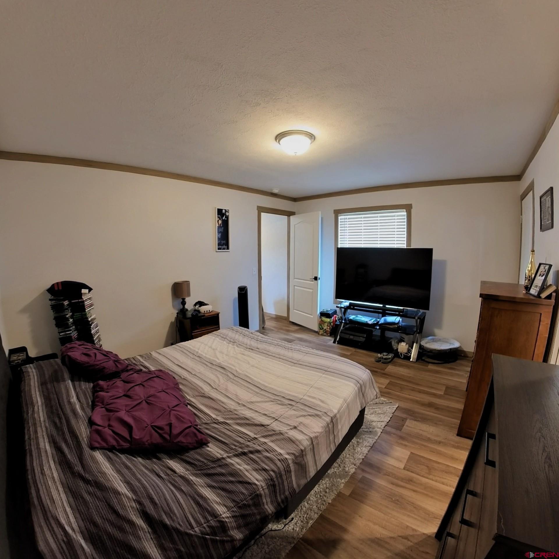 62650 Lasalle Road, Unit 822 Montrose, CO 81403 - Photo 12 of 17 a bedroom with a bed and a flat screen tv