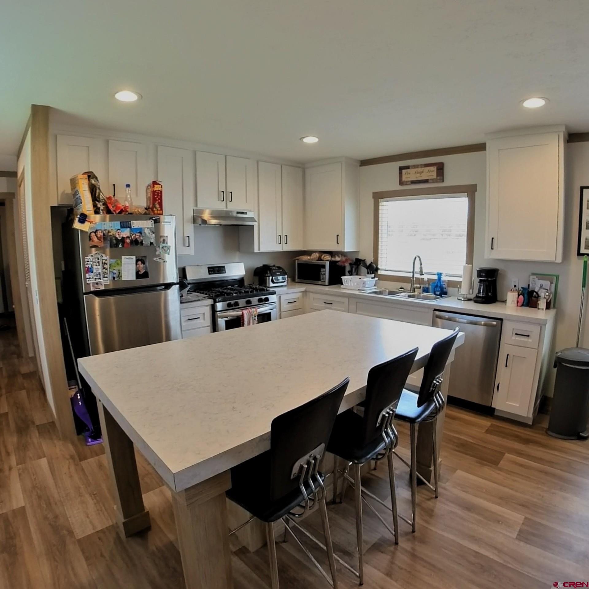 62650 Lasalle Road, Unit 822 Montrose, CO 81403 - Photo 10 of 17 a kitchen with a dining table chairs and refrigerator