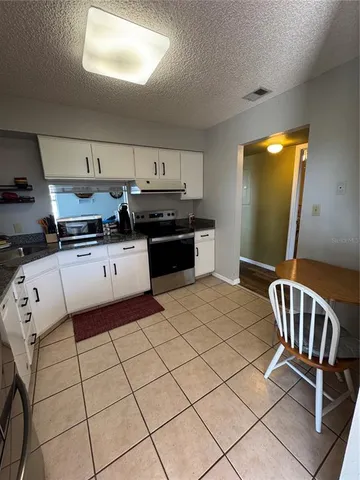 a kitchen with stainless steel appliances a sink a stove a refrigerator and cabinets