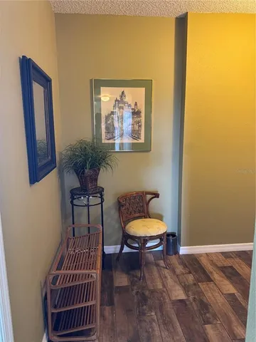a view of a hallway with wooden floor and a bathroom