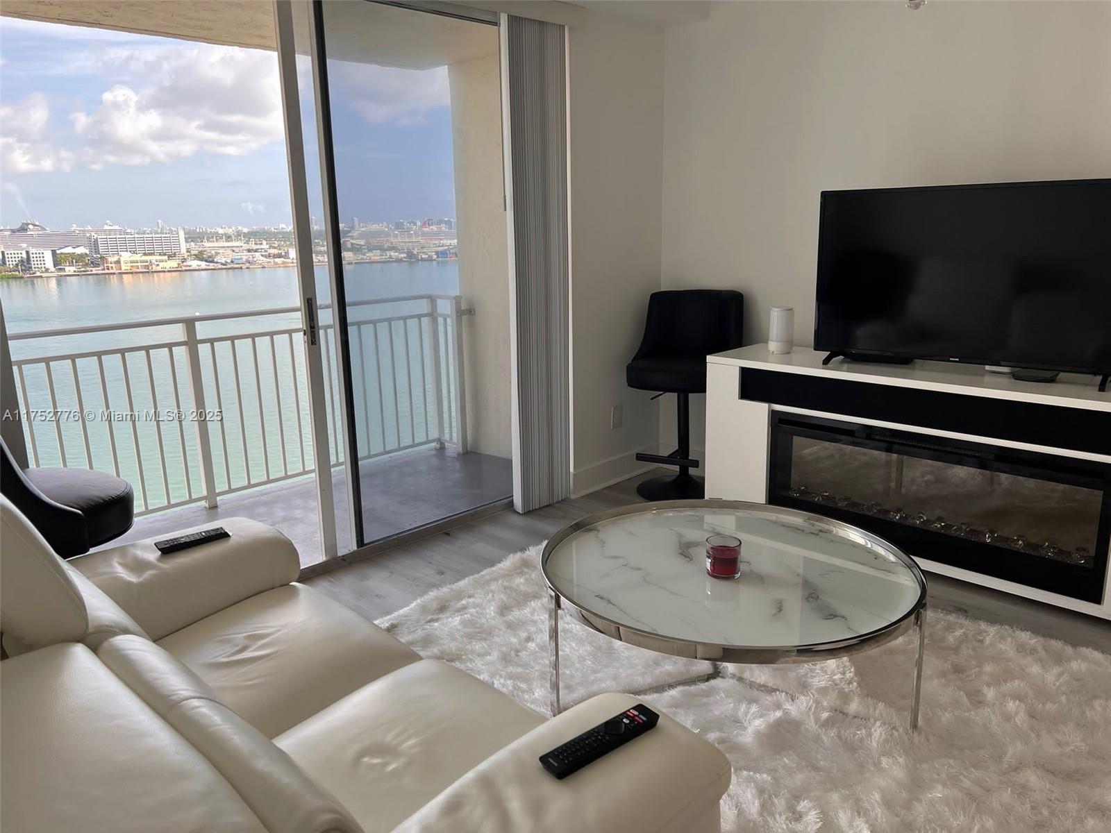 770 Claughton Island Drive, Unit 1913 Miami, FL 33131 - Photo 3 of 9 a living room with a flat screen tv and a fireplace