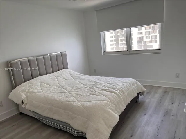 a large bed sitting in a bedroom next to a window