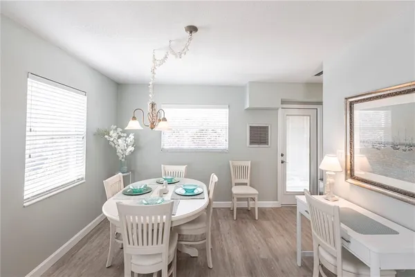 a dining room with furniture a chandelier and wooden floor