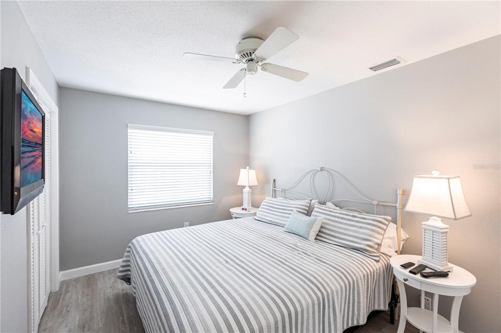 6020 Midnight Pass Road, Unit 11 Sarasota, FL 34242 - Photo 17 of 29 a bedroom with a bed and a flat screen tv