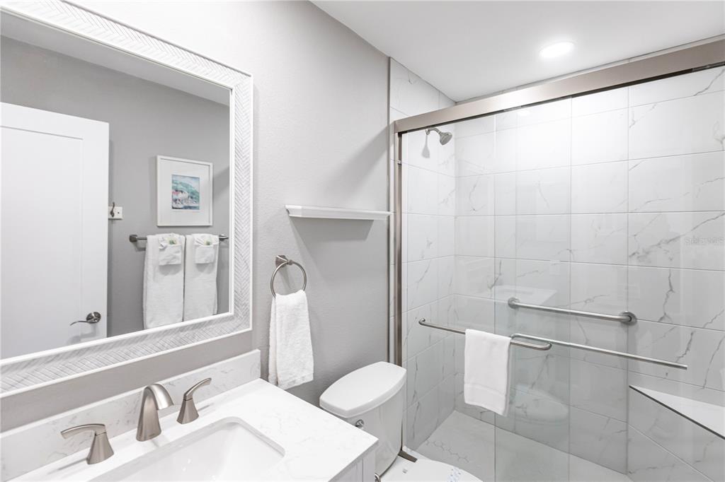 6020 Midnight Pass Road, Unit 11 Sarasota, FL 34242 - Photo 18 of 29 a white toilet sitting next to a bathroom sink