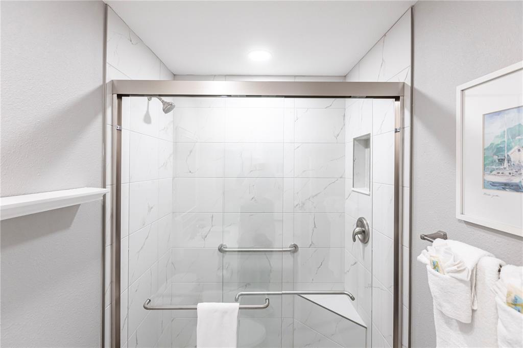 6020 Midnight Pass Road, Unit 11 Sarasota, FL 34242 - Photo 20 of 29 a bathroom with a glass shower door