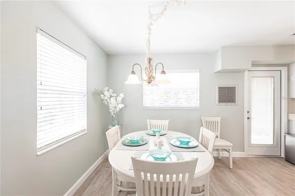 a dining room with furniture a chandelier and wooden floor