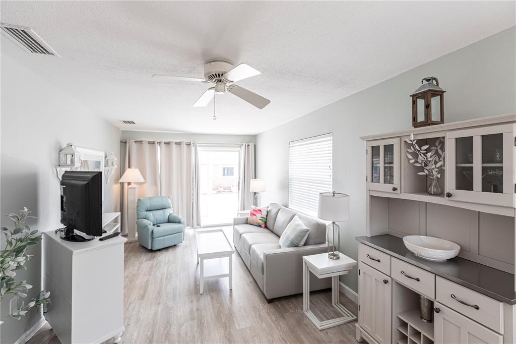 6020 Midnight Pass Road, Unit 11 Sarasota, FL 34242 - Photo 5 of 29 a living room with furniture a flat screen tv and a window