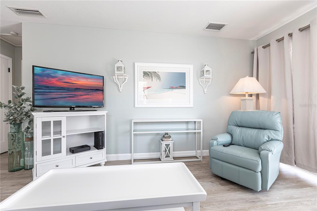 6020 Midnight Pass Road, Unit 11 Sarasota, FL 34242 - Photo 8 of 29 a living room with furniture a flat screen tv and a fireplace