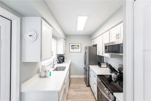 a view of a kitchen area with furniture and wooden floor