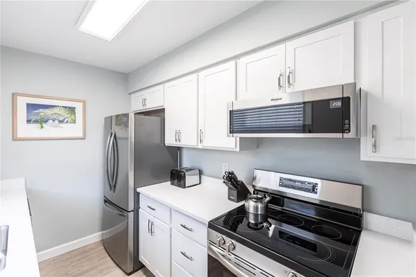 a kitchen with stainless steel appliances a refrigerator a stove a microwave and cabinets