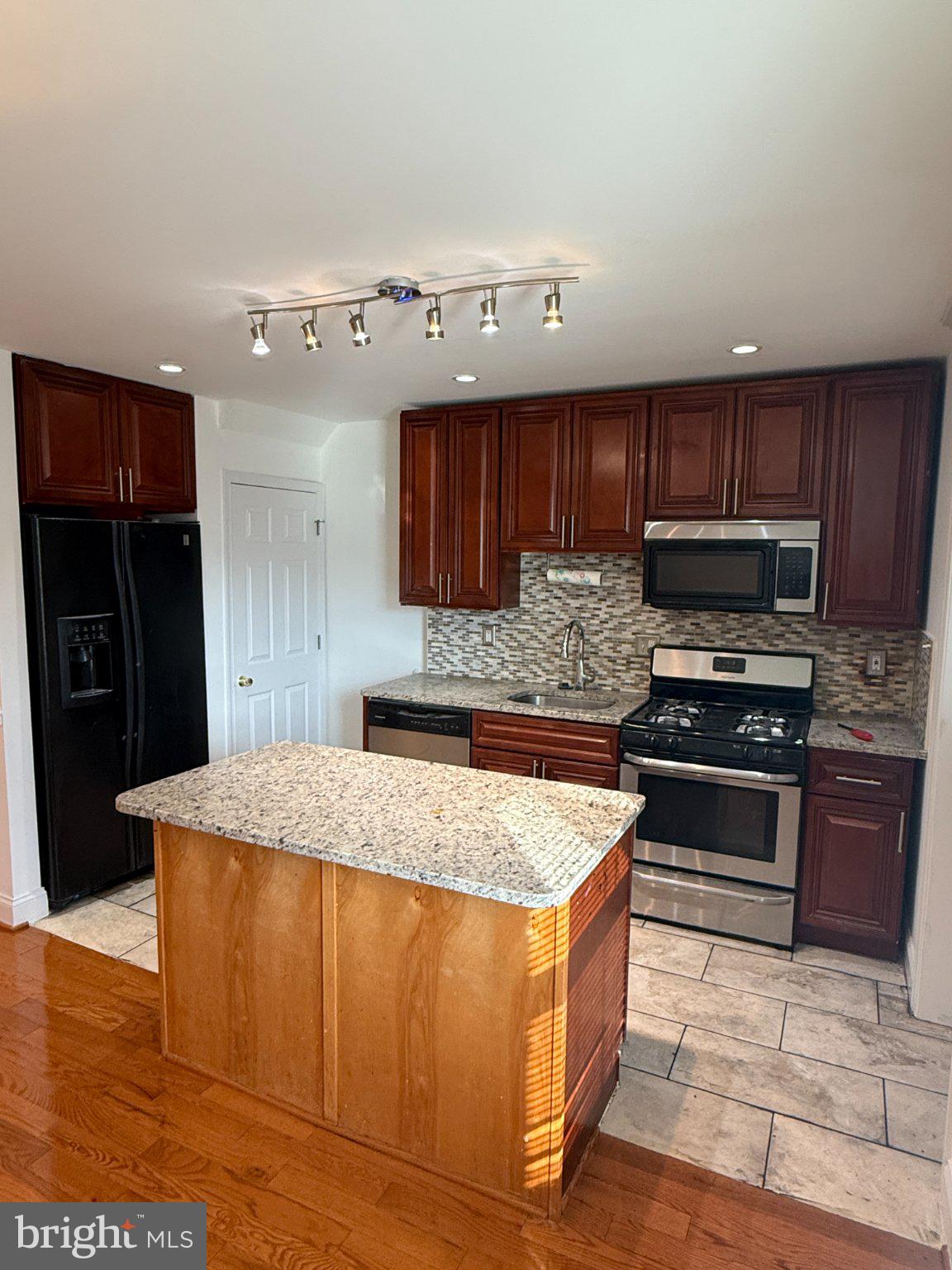 1907 Penhall Road Dundalk, MD 21222 - Photo 33 of 64 a kitchen with stainless steel appliances granite countertop a stove refrigerator and cabinets