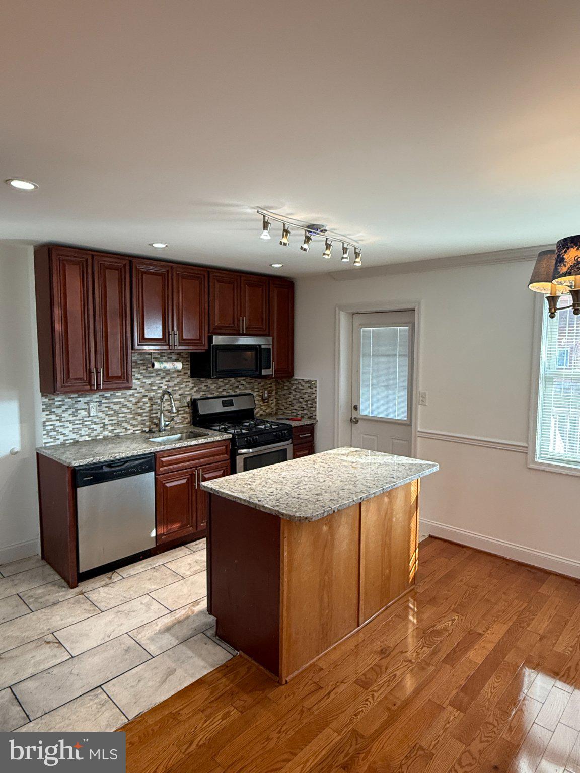 1907 Penhall Road Dundalk, MD 21222 - Photo 36 of 64 a large kitchen with stainless steel appliances granite countertop a stove a sink dishwasher a microwave oven with granite countertops and cabinets