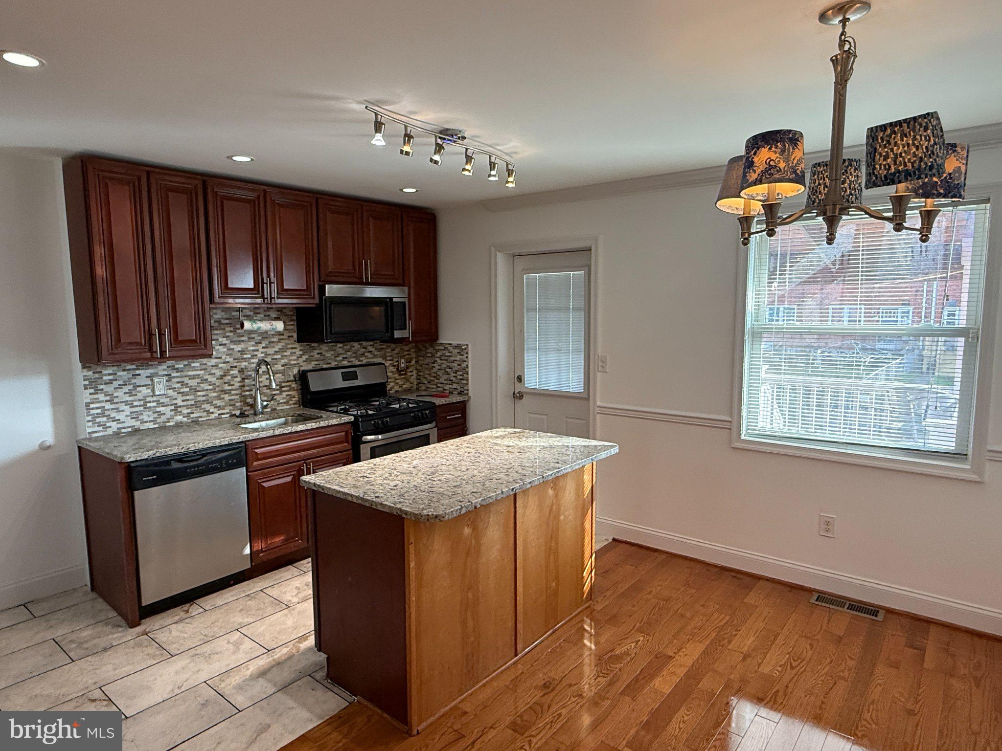 1907 Penhall Road Dundalk, MD 21222 - Photo 38 of 64 a kitchen with granite countertop a sink stove and refrigerator