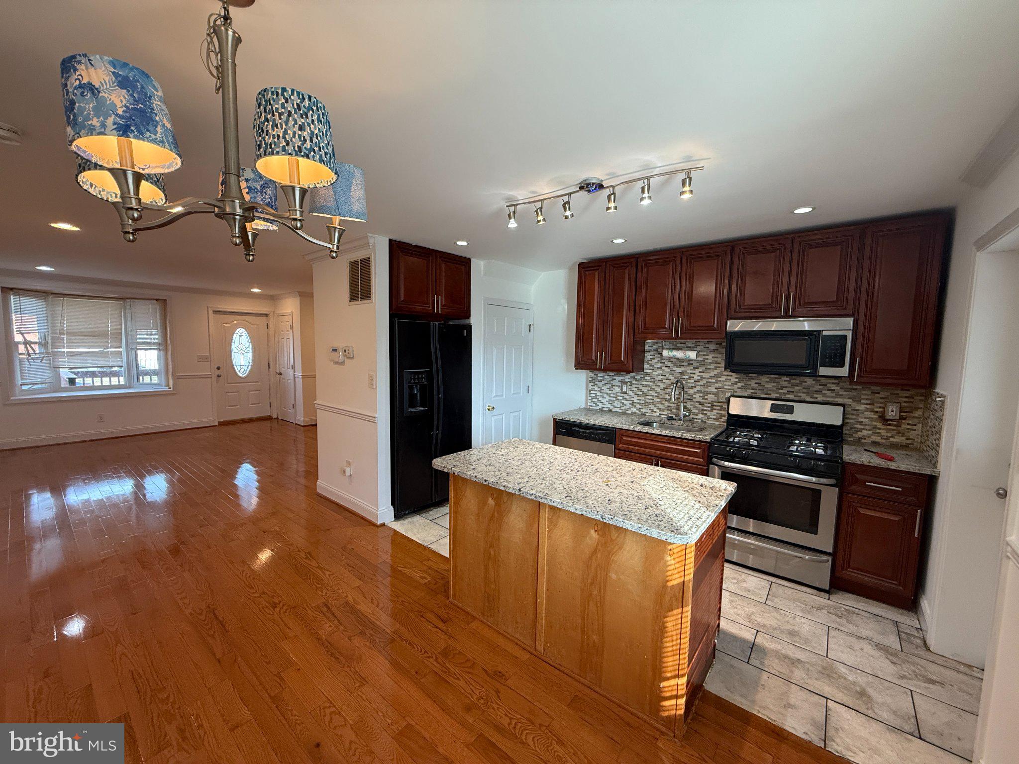 1907 Penhall Road Dundalk, MD 21222 - Photo 41 of 64 a kitchen with stainless steel appliances granite countertop wooden cabinets a stove a sink and a refrigerator