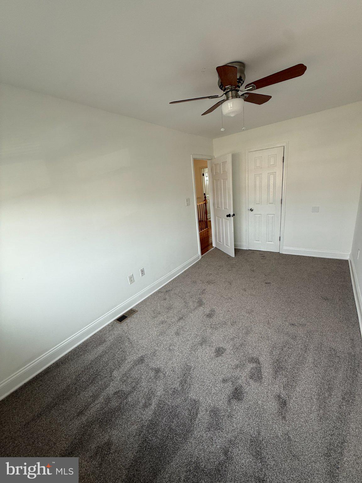 1907 Penhall Road Dundalk, MD 21222 - Photo 51 of 64 an empty room with a ceiling fan and window