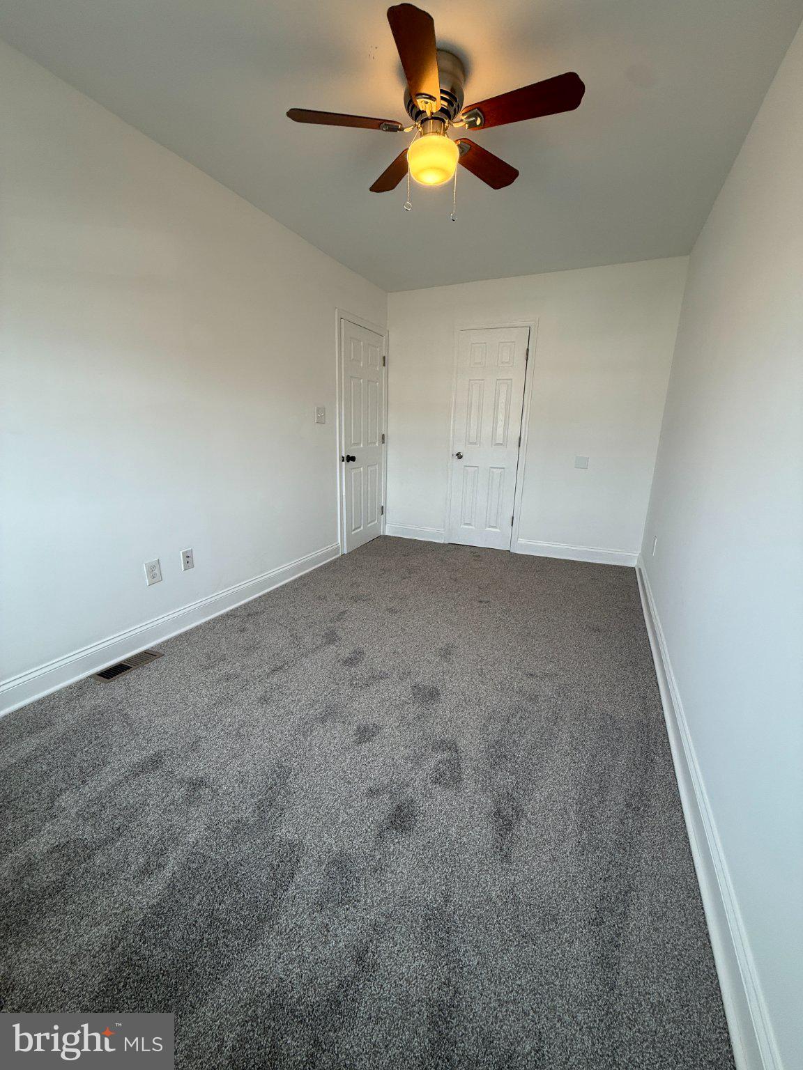 1907 Penhall Road Dundalk, MD 21222 - Photo 54 of 64 an empty room with a ceiling fan and a window