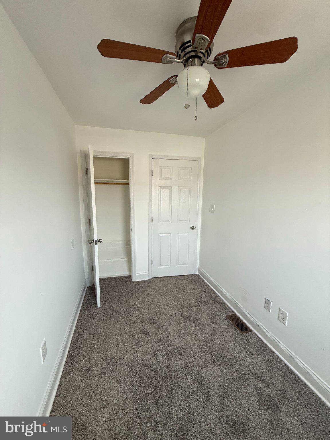 1907 Penhall Road Dundalk, MD 21222 - Photo 62 of 64 an empty room with a ceiling fan and carpet