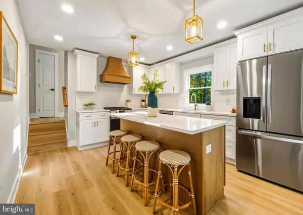 a kitchen with stainless steel appliances granite countertop a sink a stove and a refrigerator