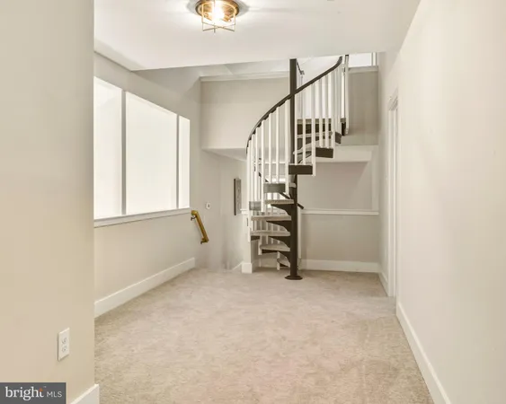 a view of an empty room with stairs and a window