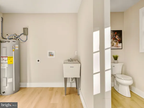 a view of a hallway with wooden floor and a bathroom view